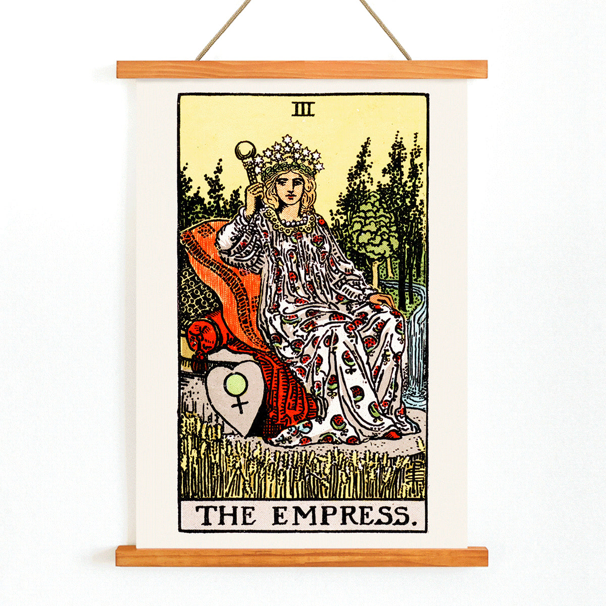 The Empress Tarot card by Rider Waite featuring a crowned woman seated on a throne in a lush natural setting holding a scepter with a crown of stars, with wooden magnetic frame on white background