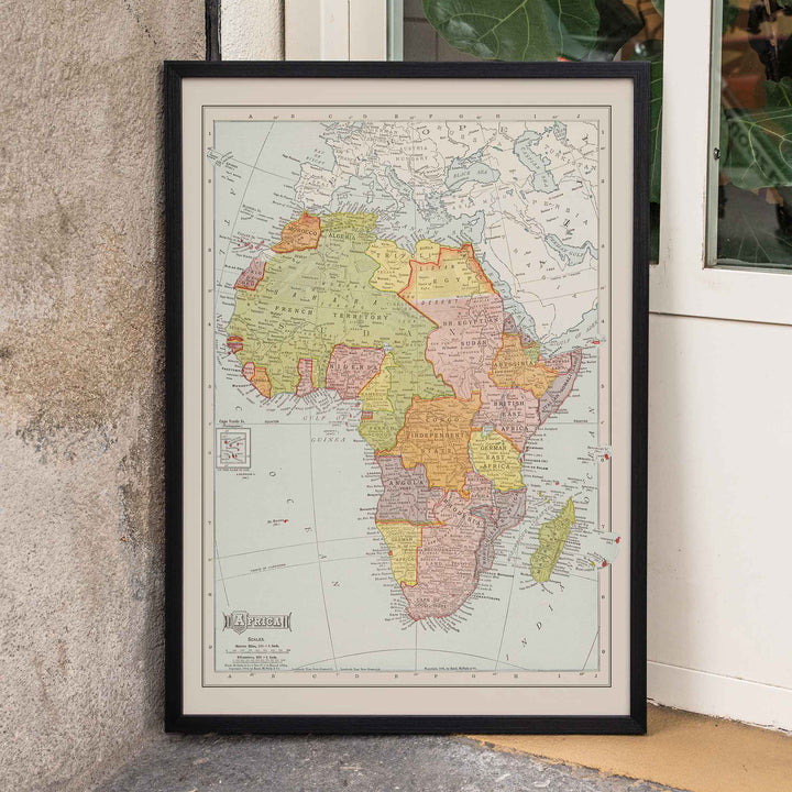 Rand McNally and Company Africa Map vintage poster of the African continent in muted green yellow pink and beige tones, framed and displayed in home decor