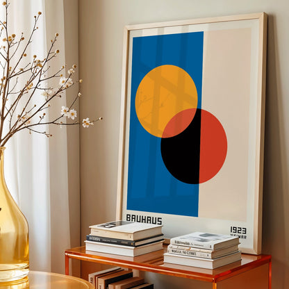 Bauhaus Poster 17 abstract geometric design with intersecting circles in orange red black on blue and beige background by Bauhaus artist framed with text at the bottom, framed and displayed in home decor