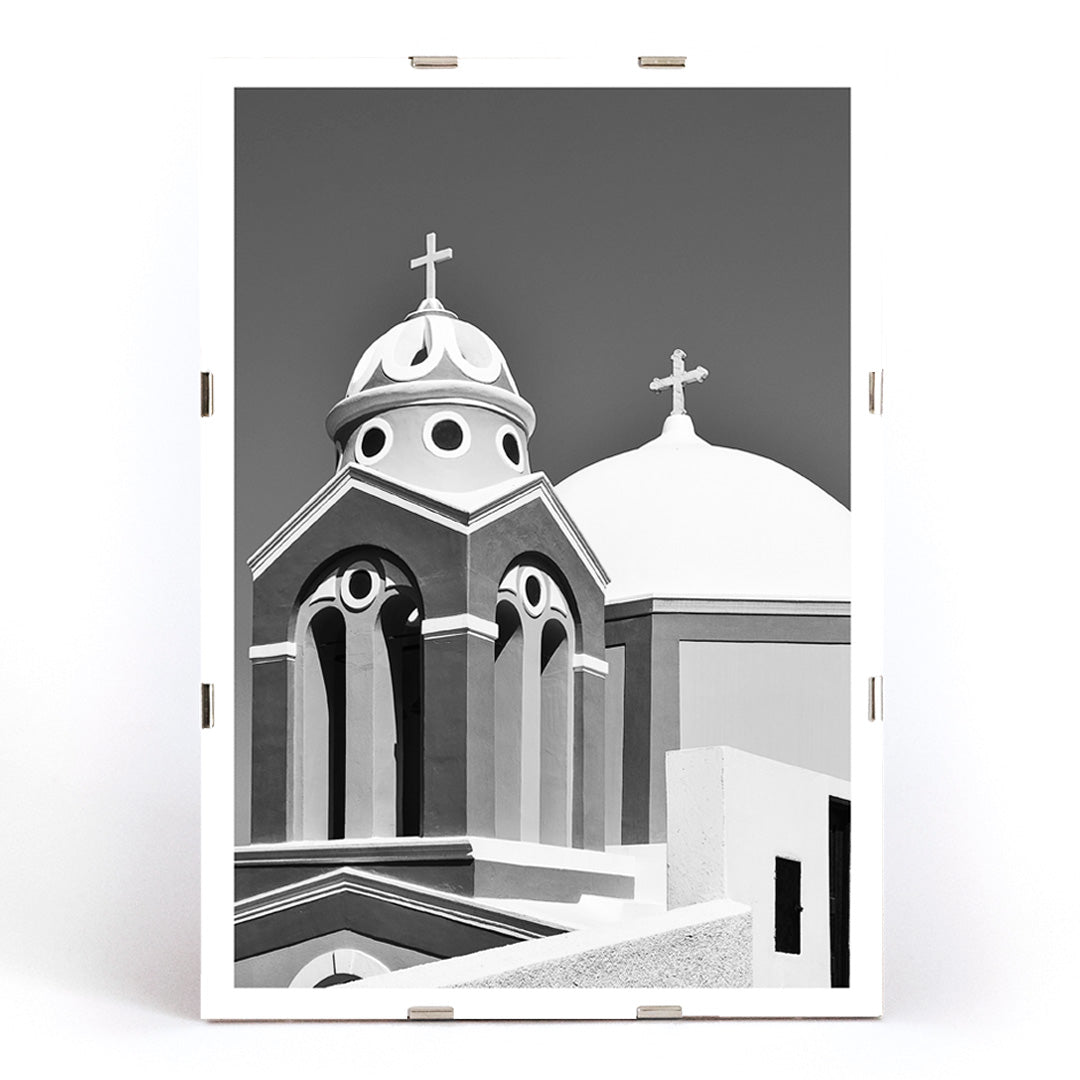 Black and white artwork of a traditional church dome and cross in Santorini Greece by artist Santorini Greece poster featuring classic architecture against a clear sky, framed and displayed in modern living room decor