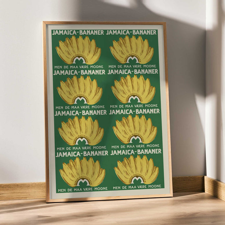 Jamaica Bananas poster with repeated ripe yellow banana bunches on a deep green vintage advertising design, framed and displayed in modern living room decor