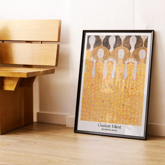Beethoven Frieze by Gustav Klimt featuring women in flowing yellow gowns with intricate golden and orange patterns and faceless figures, framed and displayed in home decor