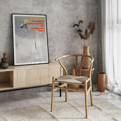 Black and white photo and poster of a kite tangled on a telephone line with bold warning text Keep kites and classified information off telephone lines, framed and displayed in home decor