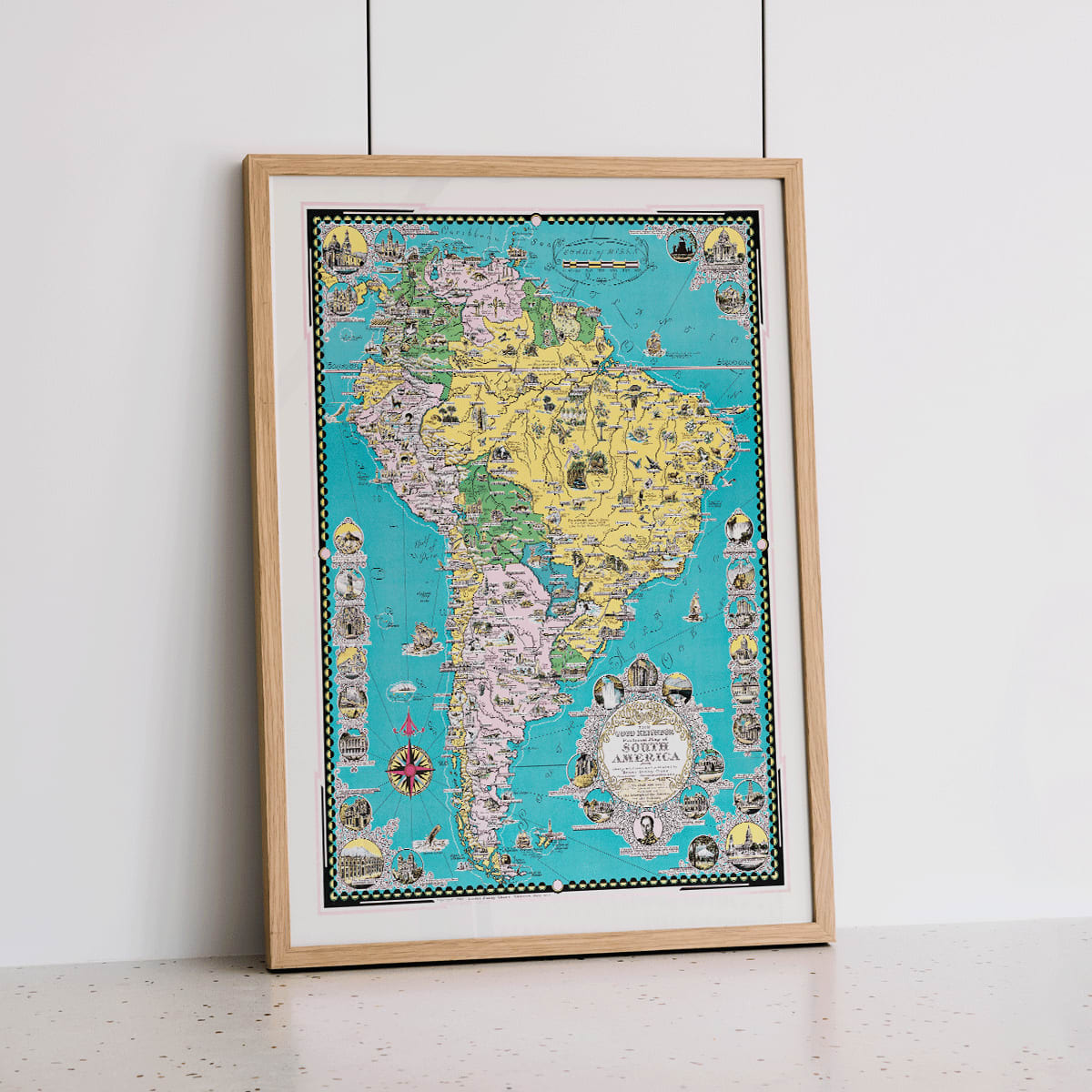 Colorful illustrated map poster of South America by Ernest Dudley Chase titled The Good Neighbor of South America, framed and displayed in home decor