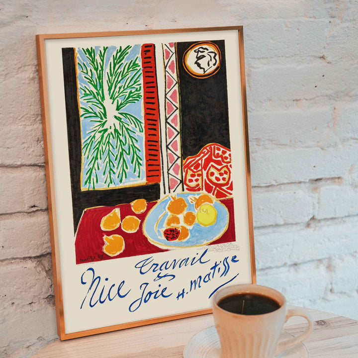 Henri Matisse Nice Travail et Joie poster with palm fronds, fruit on a blue plate, and bold red and black shapes, with wooden magnetic frame on white background