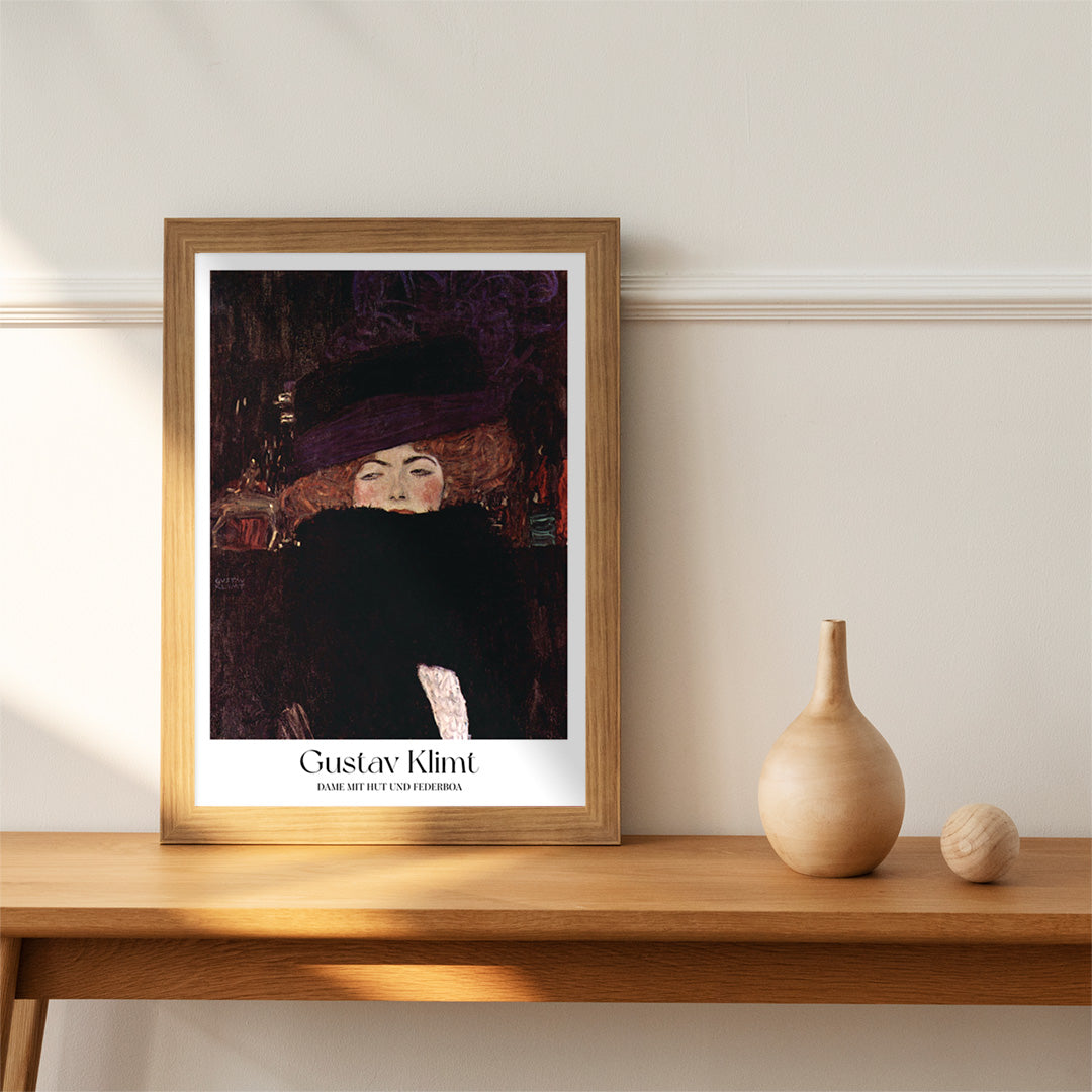 Elegant woman with hat and feather boa painted by Gustav Klimt Dame mit Hut und Federboa poster showing a woman in elegant attire, framed and displayed in home decor