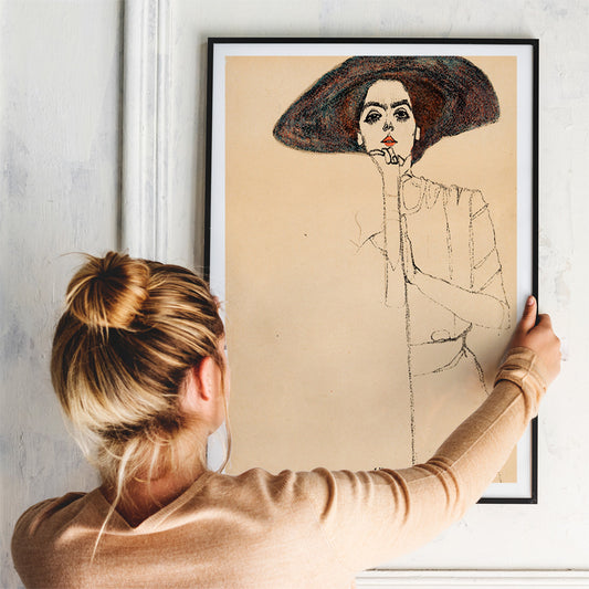 Frauenbildnis II by Egon Schiele poster featuring a woman in a large hat expressive minimalistic line drawing on beige background, framed and displayed in home decor