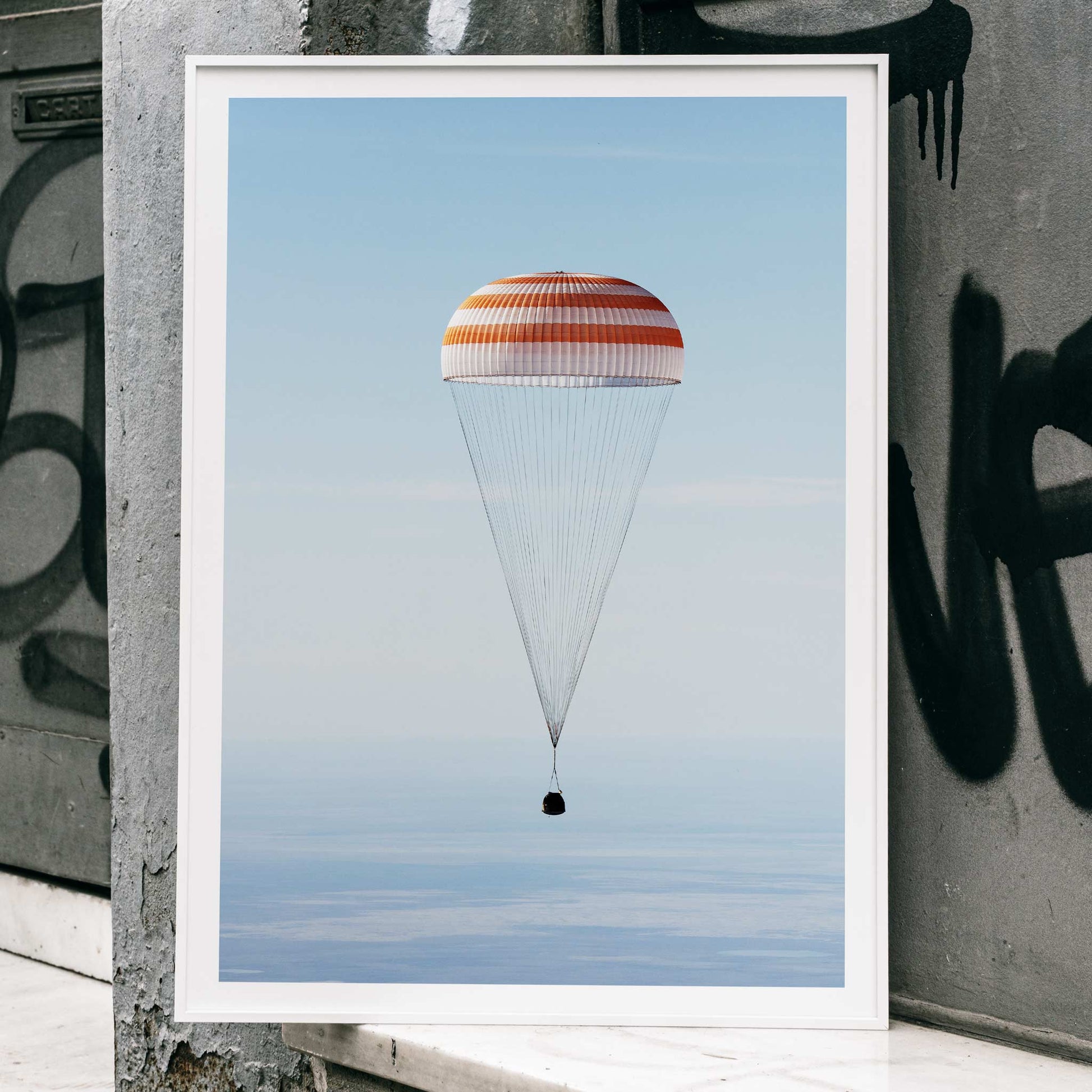 Soyuz MS-02 spacecraft descending with parachute over Kazakhstan NASA poster titled The Soyuz MS-02 spacecraft lands, framed and displayed in home decor