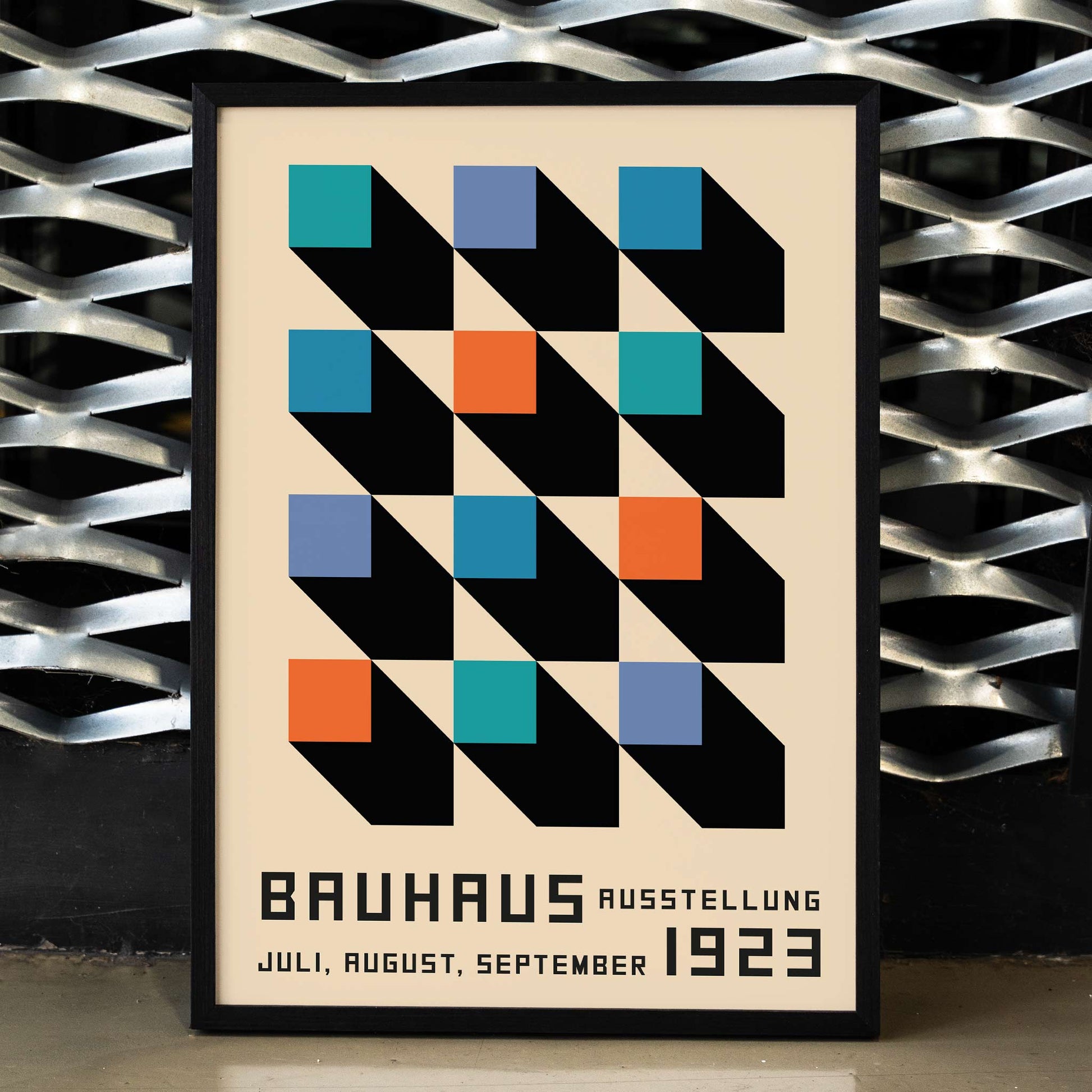 Bauhaus Poster inspired by the Weimar Exhibition with geometric patterns bold colors by Joost Schmidt in black blue orange and teal squares, framed and displayed in home decor
