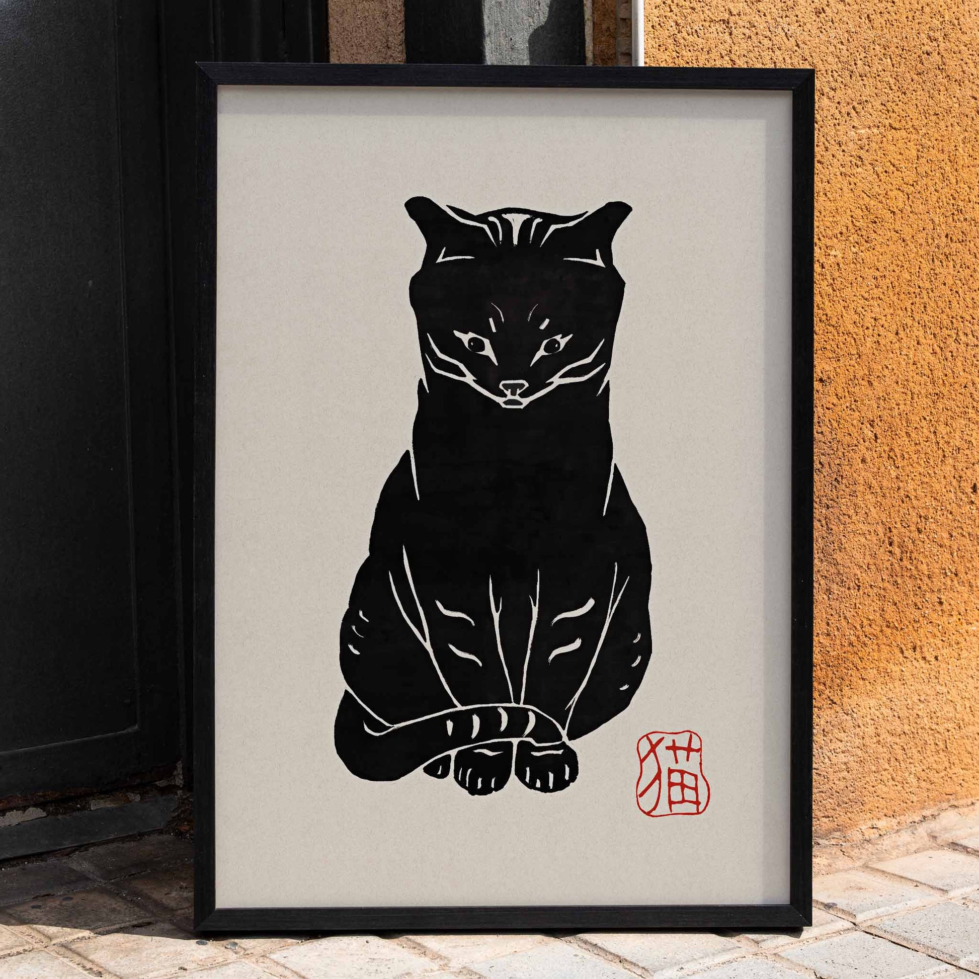 Black Cat artwork by unknown artist and Anonymous featuring a stylized minimalist black cat on beige background with red stamp detail, framed and displayed in home decor
