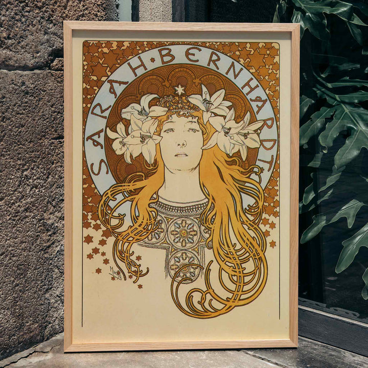 Art Nouveau poster of Sarah Bernhardt with flowing hair floral crown and lilies by Alphonse Mucha from La Plume, framed and displayed in home decor