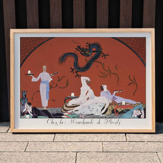 Opulent oriental scene with reclining figures and a blue dragon in Chez la Marchande de Pavots by George Barbier poster on a red background, framed and displayed in home decor