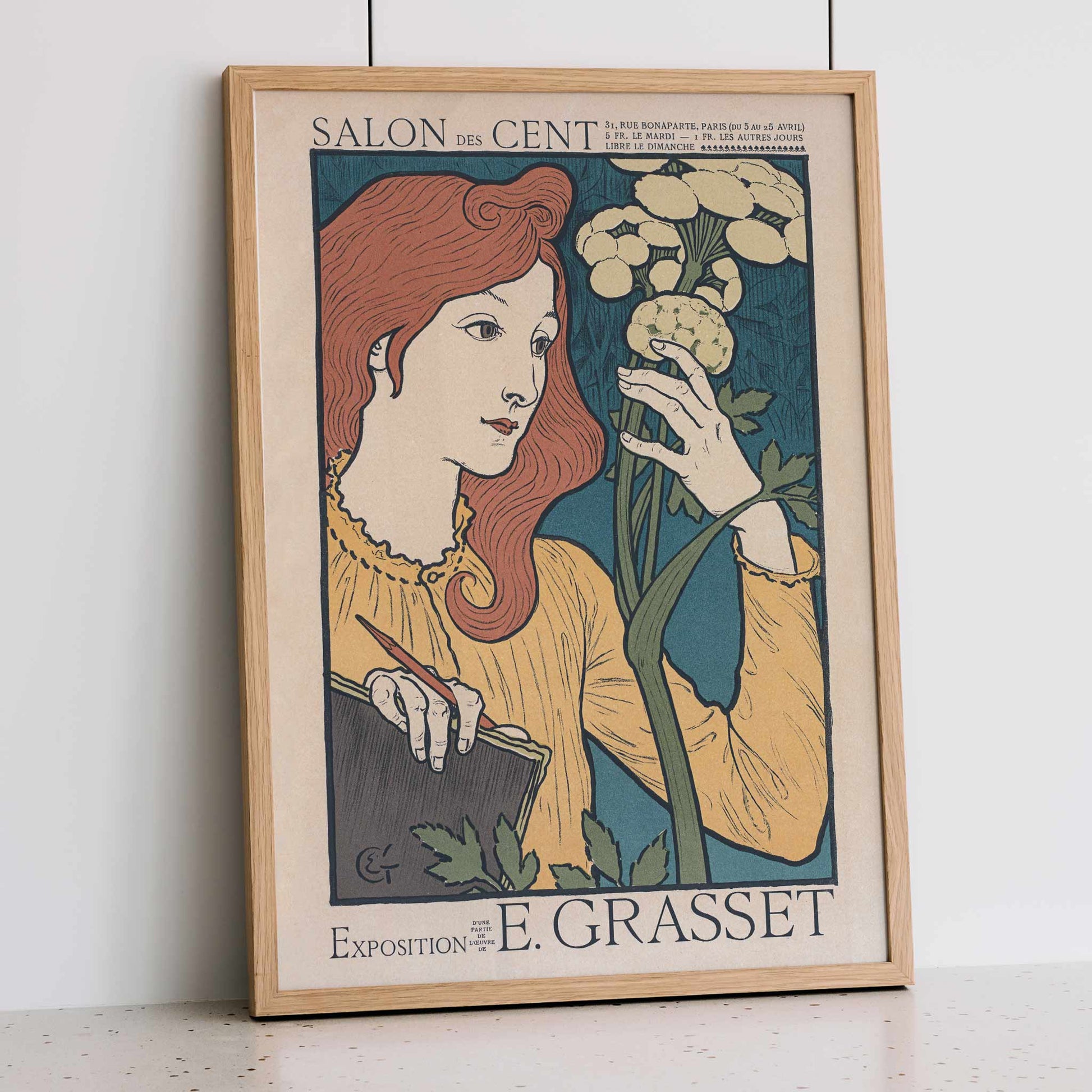Eugène Grasset Salon des Cent poster featuring a red haired woman with flowers in cream teal and yellow Art Nouveau style, framed and displayed in modern living room decor