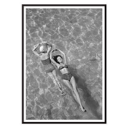 Fashion models in vintage bathing suits floating in a swimming pool artwork by Toni Frissell, with black aluminium frame on white background