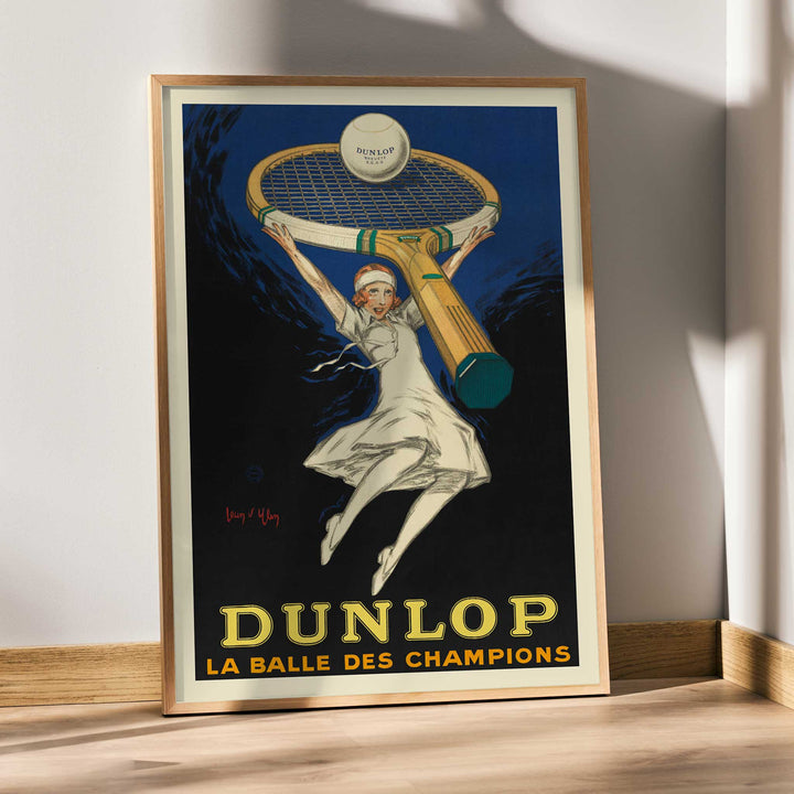 Jean dYlen Dunlop The Ball of Champions poster with leaping tennis player giant racket and ball in bold blue and black, framed and displayed in modern living room decor