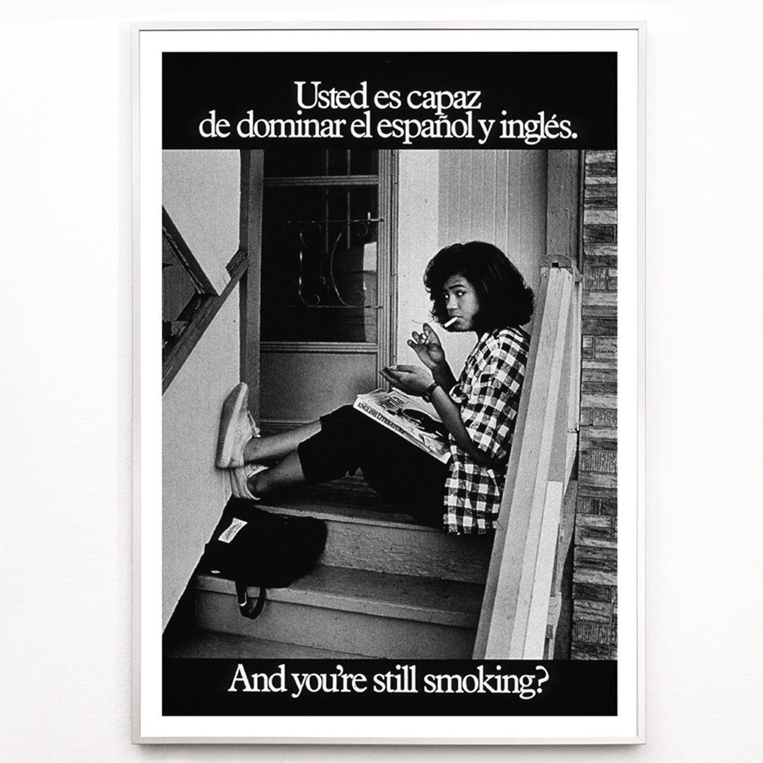 Closeup detail of Young woman reading and smoking on stairs in bilingual anti-smoking poster by US Department of Health and Human Services titled Usted es capaz de dominar el español y inglés and you are still smoking